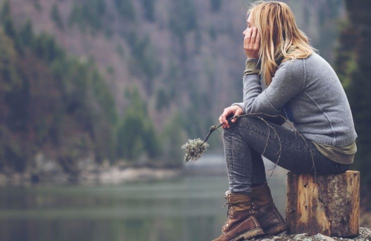 Frau meditiert am See