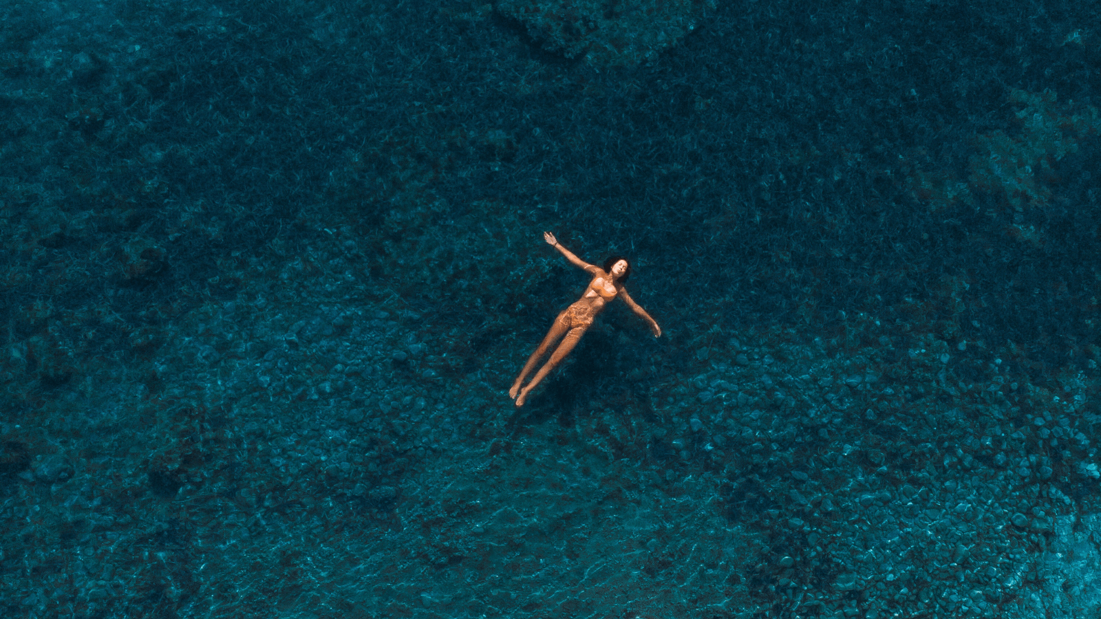 Frau treibt auf dem Rücken im Meer