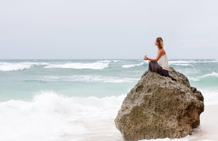 Frau auf Felsen am Meer