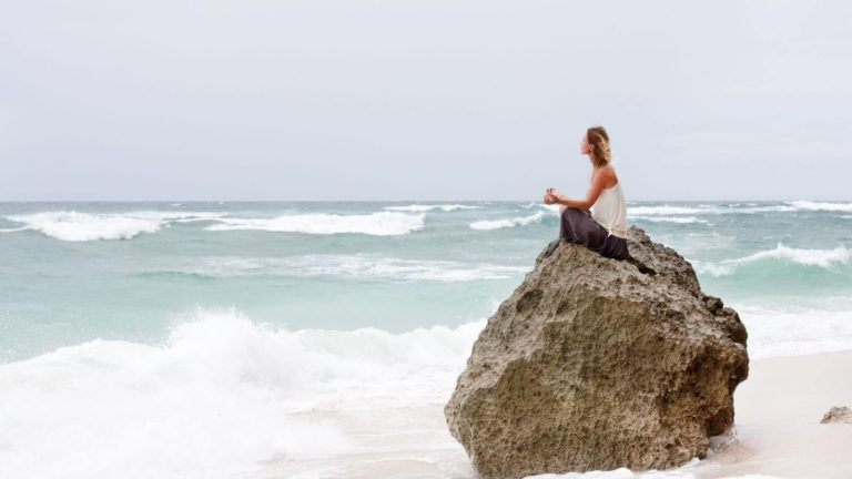 Frau auf Felsen am Meer