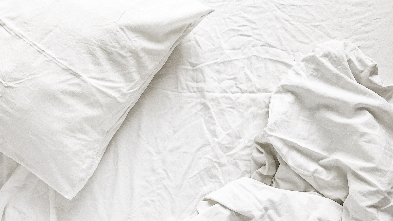 Weiß bezogenes nicht gemachtes Bett