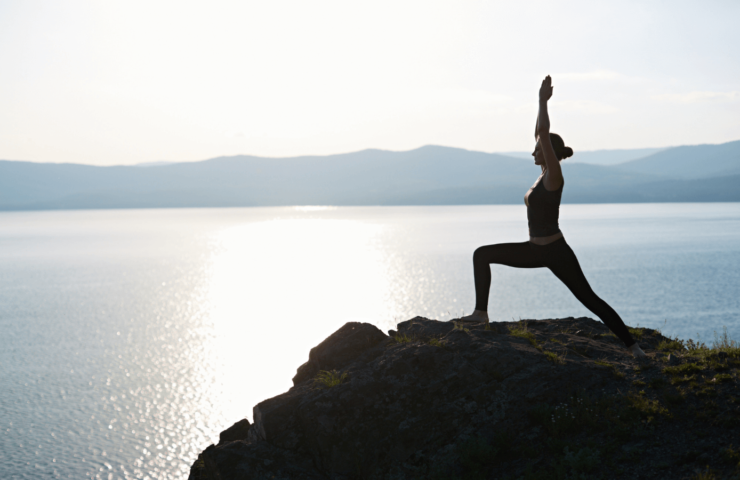 Frau, die Yoga am Meer macht