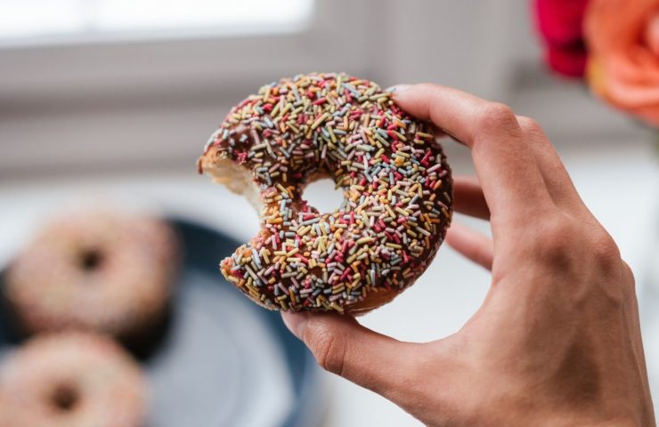 Angebissener Donut mit bunten Zuckerstreuseln