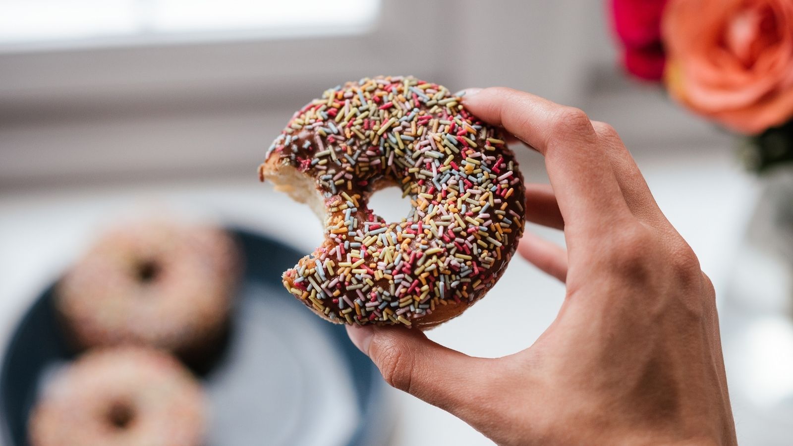 Angebissener Donut mit bunten Zuckerstreuseln