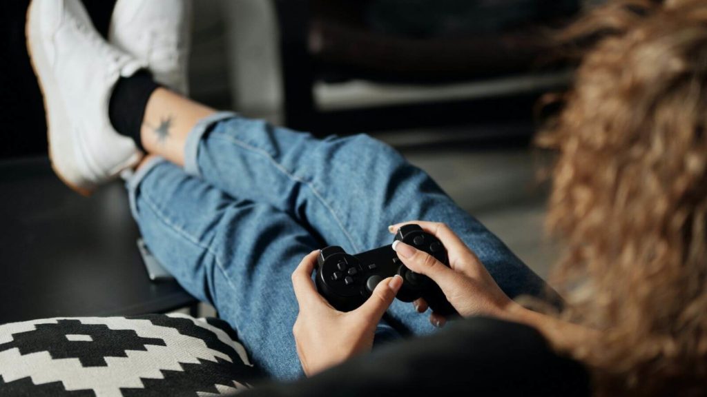 Junge Frau, die Playstation spielt