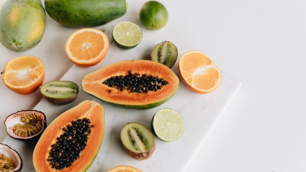 Aufgeschnittene Papaya, Kiwis und Orangen