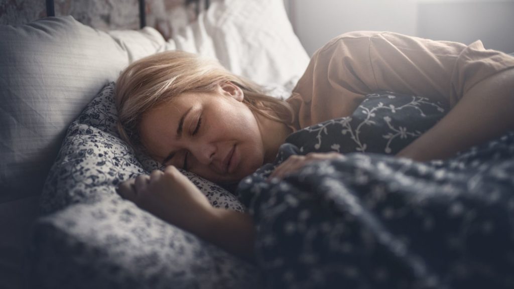 Frau schläft im Bett dank Melatonin