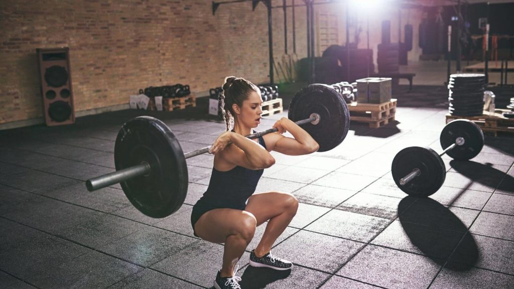 Frau mit Langhantel beim HIT Training