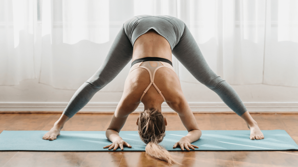 Frau, die mit einer Matte Yoga macht