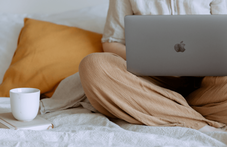 Nahaufnahme Laptop und Kaffee im Bett