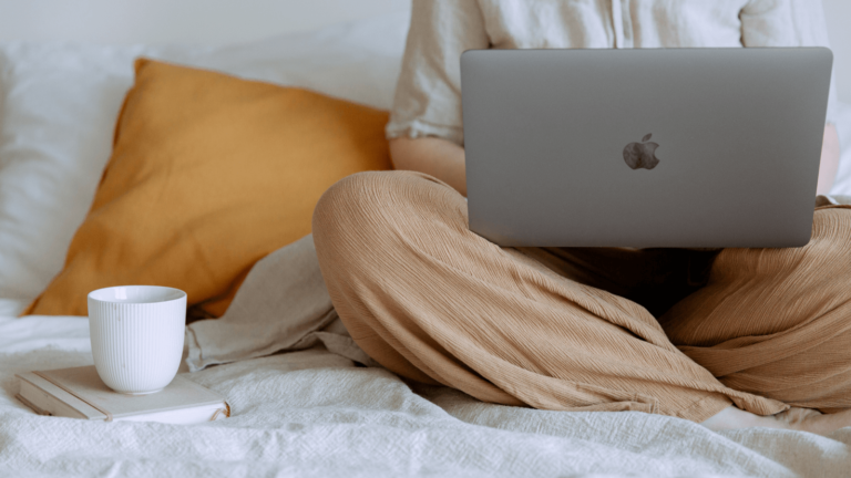 Nahaufnahme Laptop und Kaffee im Bett