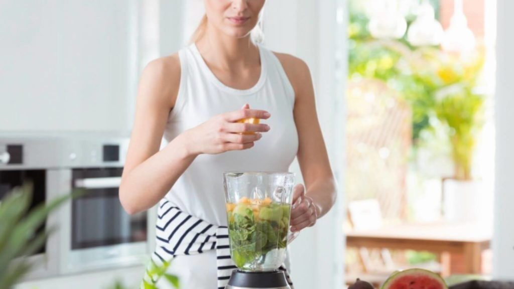 Frau bereitet Smoothie zu