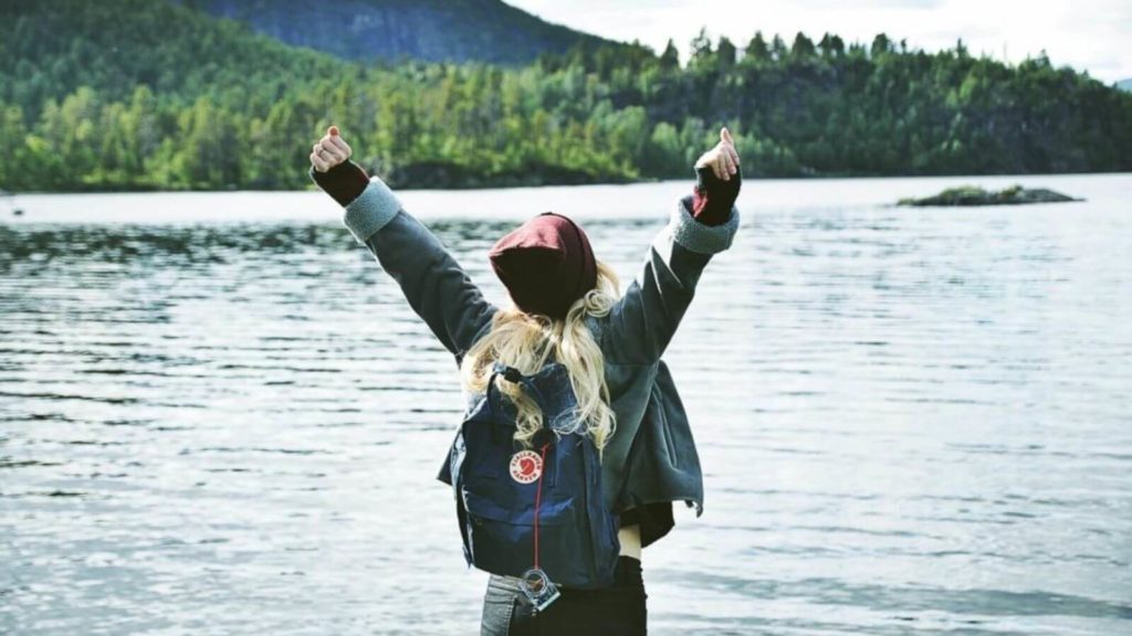 Frau in Siegerpose am See