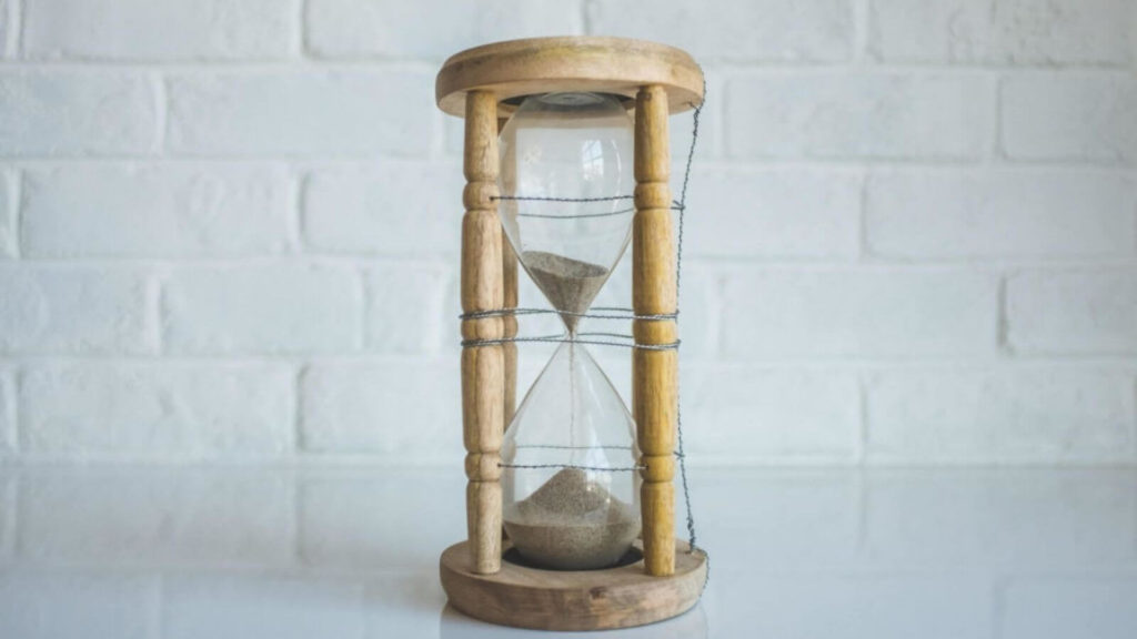Sanduhr als Metapher für die Lebenszeit, die durch Sirtuine reguliert wird.