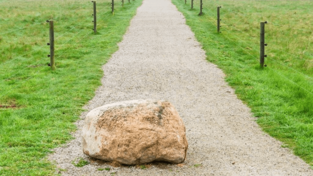 Felsen auf Gehweg als Sinnbild einer Blockade